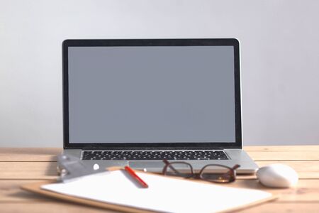 Laptop stands on a wooden table .の写真素材