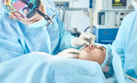 Several doctors surrounding patient on operation table during tの写真素材