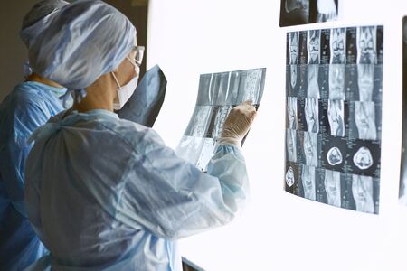 Two female women medical doctors looking at x-rays in a hospitalの写真素材