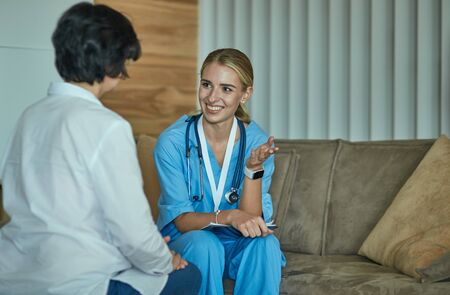Friendly smiling doctor and patient sitting on the couch. Veryの写真素材