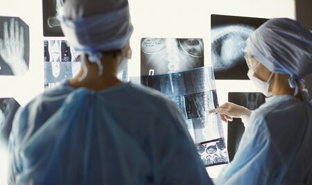 Two female women medical doctors looking at x-rays in a hospitaの写真素材