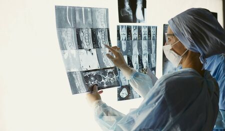 Two female women medical doctors looking at x-rays in a hospitaの写真素材