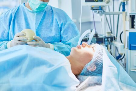 Several doctors surrounding patient on operation table during their work. Team surgeons at work in operating room.の写真素材