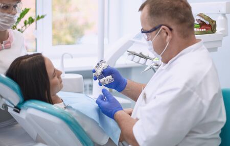 Doctor dentist treats teeth of a beautiful young girl patient. The girl on reception at the dentist. Doctor dentist treats tooth.の写真素材