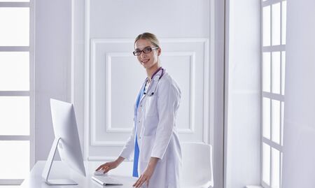 Portrait of a happy smiling young doctor in headset in officeの写真素材