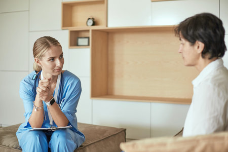 Friendly smiling doctor and patient sitting on the couch. Very good news and high level medical care...