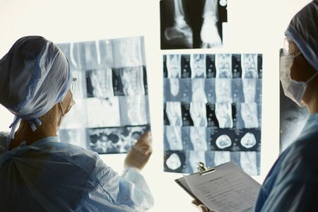 Two female women medical doctors looking at x-rays in a hospital.の写真素材