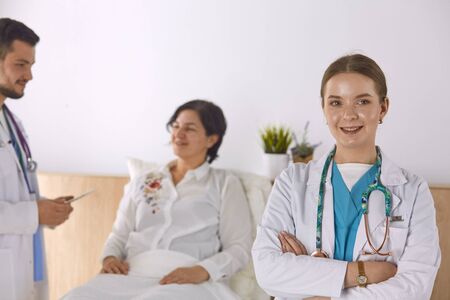 Patient with a group of doctors at the backgroundの写真素材