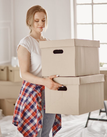A beautiful single young woman unpacking boxes and moving into a new home