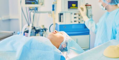 Several doctors surrounding patient on operation table during their work. Team surgeons at work in operating room.の写真素材