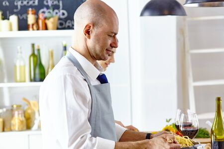 Smiling young couple cooking food in the kitchenの写真素材