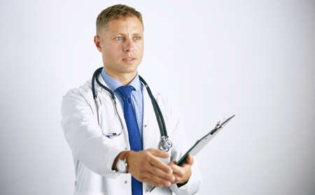 Young doctor in white coat with a stethoscope greets holding out his handの写真素材