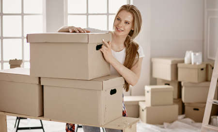 A beautiful single young woman unpacking boxes and moving into a new homeの写真素材