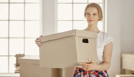 A beautiful single young woman unpacking boxes and moving into a new homeの写真素材