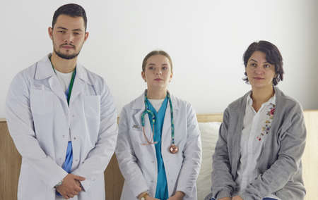 Patient with a group of doctors at the backgroundの写真素材