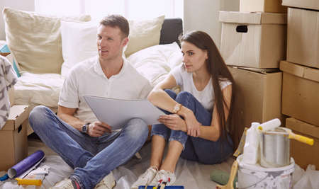 Young Hispanic couple looking at blueprints of new home, high angle viewの写真素材