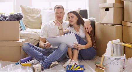 Young Hispanic couple looking at blueprints of new home, high angle viewの写真素材