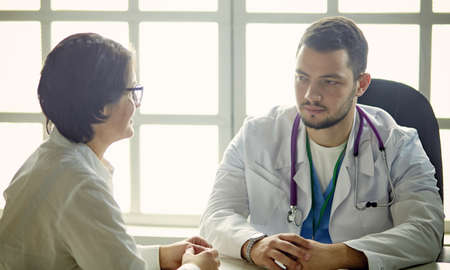 Young doctor talking to a patient in the officeの写真素材