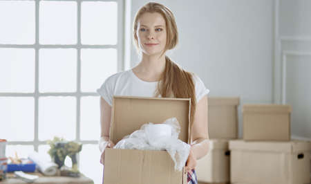 A beautiful single young woman unpacking boxes and moving into a new homeの写真素材
