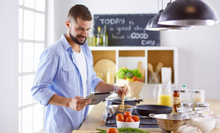 Smiling and confident chef standing in large kitchenの写真素材