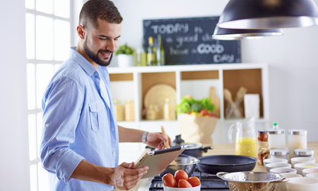 Smiling and confident chef standing in large kitchenの写真素材