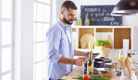Smiling and confident chef standing in large kitchenの写真素材