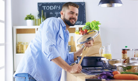 Smiling and confident chef standing in large kitchenの写真素材