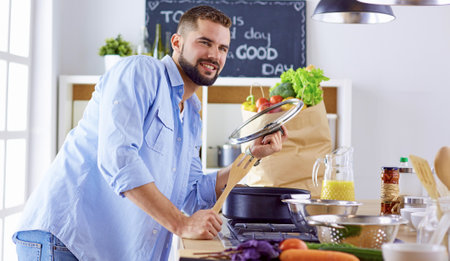 Smiling and confident chef standing in large kitchenの写真素材