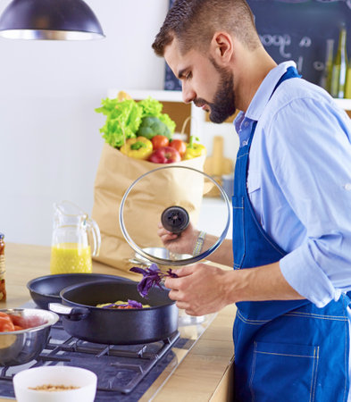 Smiling and confident chef standing in large kitchenの写真素材
