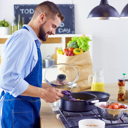 Smiling and confident chef standing in large kitchenの写真素材