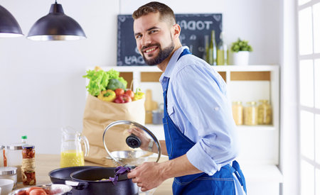 Smiling and confident chef standing in large kitchenの写真素材