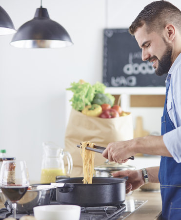 Smiling and confident chef standing in large kitchenの写真素材