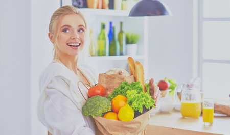 Young woman holding grocery shopping bag with vegetables Standiの写真素材