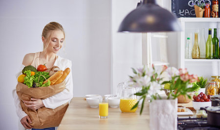 Young woman holding grocery shopping bag with vegetables Standiの写真素材