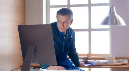 Engineer carpenter working on laptop and sketching projectの写真素材