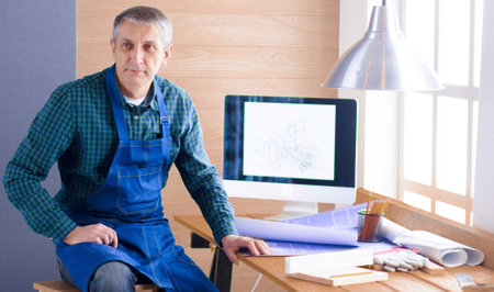 Engineer carpenter working on laptop and sketching projectの写真素材
