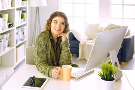 Young woman working with graphic tablet in officeの写真素材