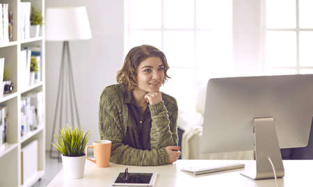 Young woman working with graphic tablet in officeの写真素材