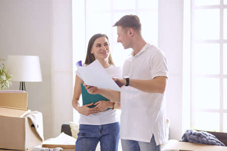 Young Hispanic couple looking at blueprints of new home, high angle viewの写真素材