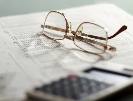 Newspaper and glasses Calculatorの写真素材