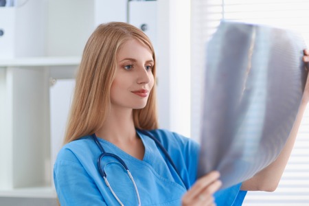 Young female doctor looking at the x-ray picture の写真素材