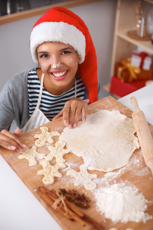 Happy young woman smiling happy having fun with Christmas preparations wearing Santa hatの写真素材