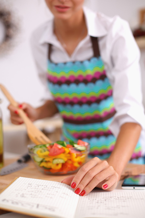 Smiling young woman  mixing fresh saladの写真素材