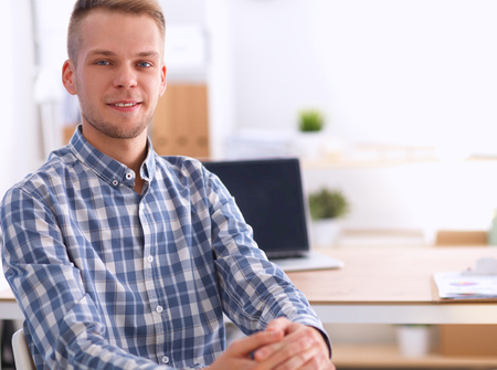 Young businessman working in office, sitting at deskの写真素材