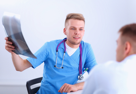 Male doctor explaining spine x-ray to patient in the medical officeの写真素材