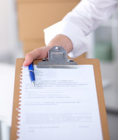 Delivery man with a parcel and a tablet isolated on whiteの写真素材