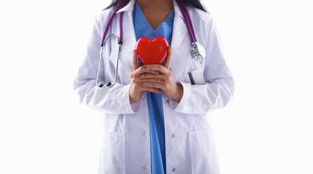 Female doctor with stethoscope holding heart, isolated on white backgroundの写真素材