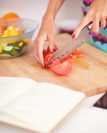 Young woman preparing salad in the kitchenの写真素材