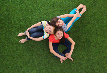 Young women sitting  on green grassの写真素材