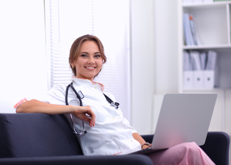 Closeup portrait of a young doctor sitting on the sofaの写真素材